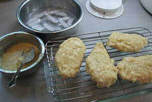 The first coating of chaud-froid has been applied and is sticking to the chicken.